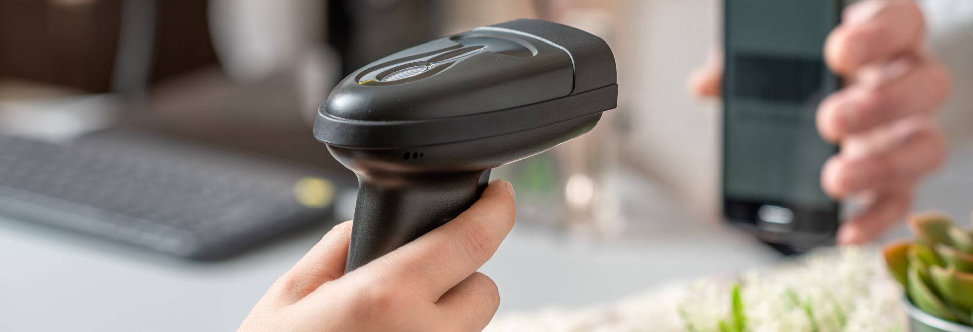 Man buying a gift in a female clothing store. Woman cashier, seller scanning qr code from buyer phone using manual scanner at the checkout.